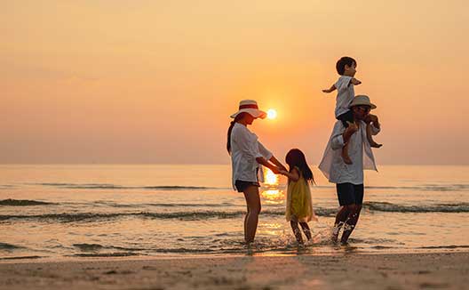 family on beach at sunset