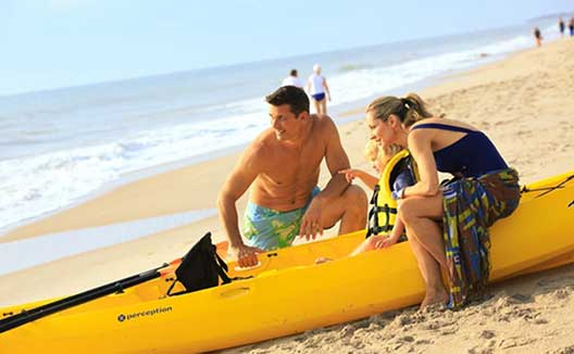mom, husband and son preparing to kayak beachfront